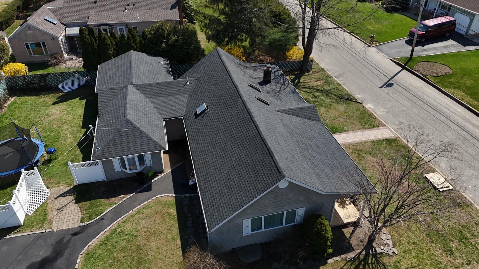 Aerial view of a ranch house with a finished gray shingle roof
