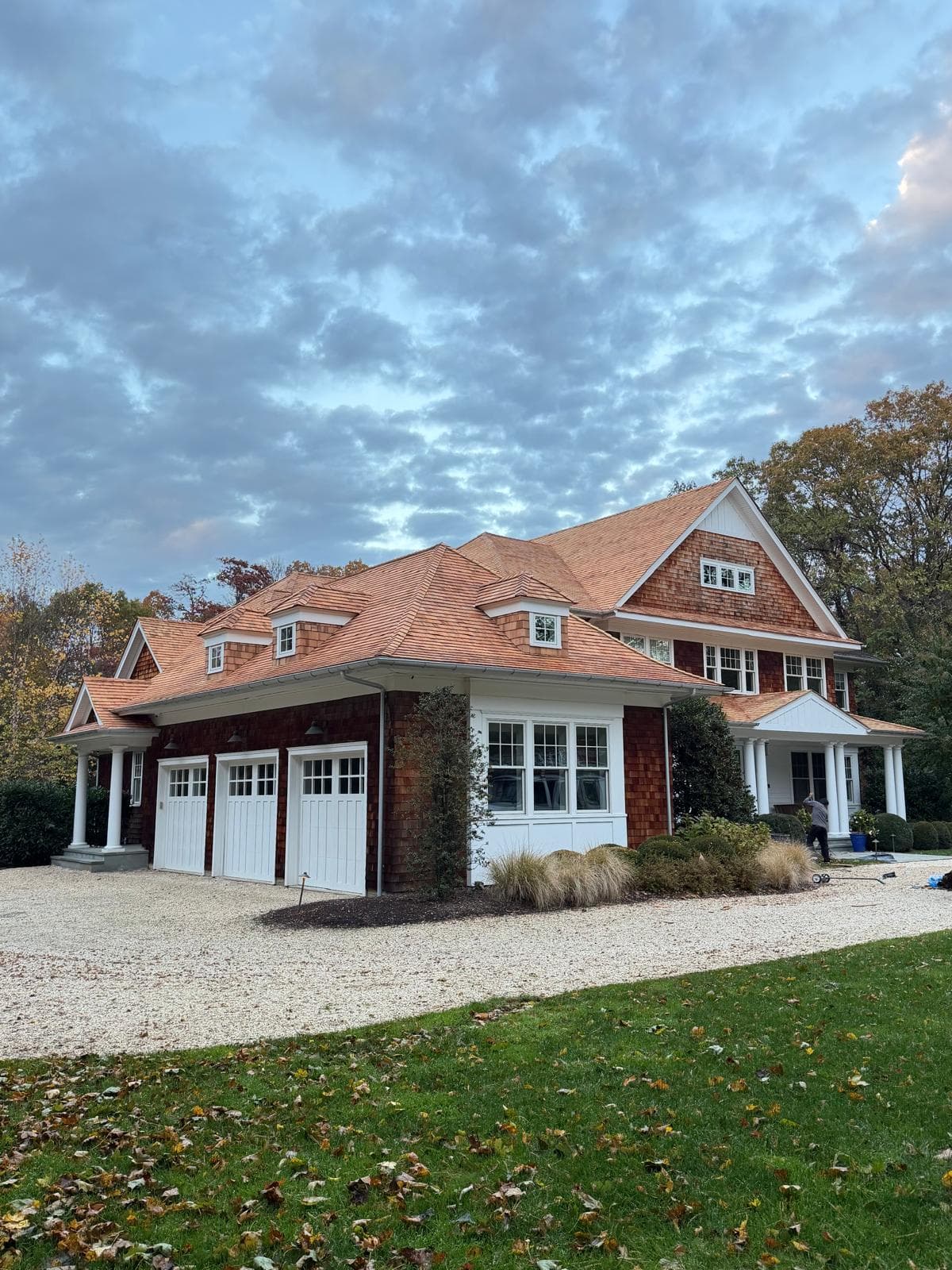 Shingle-style home with a cedar roof and a three-car garage