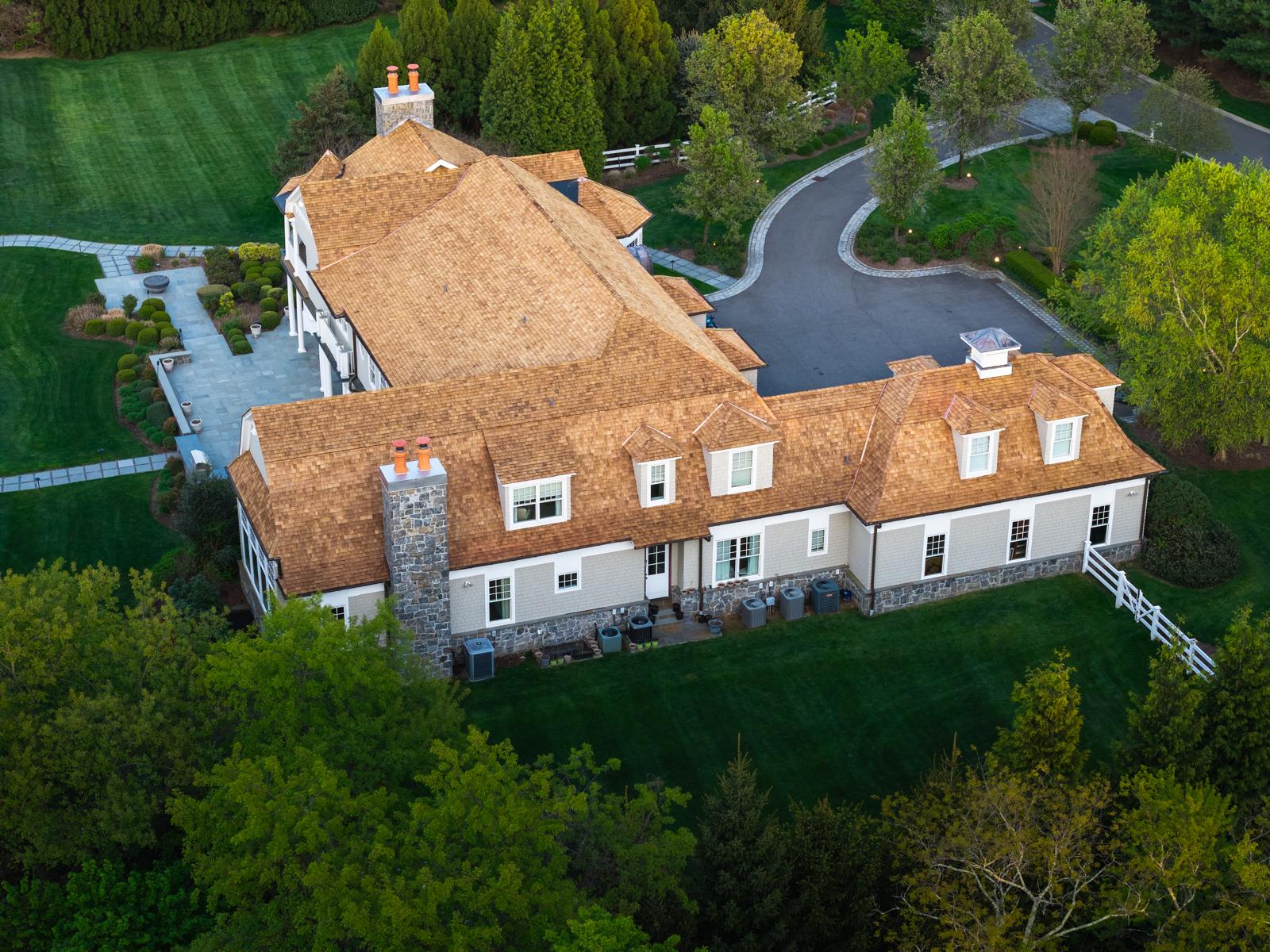 Aerial view of a large house with a cedar shake roof