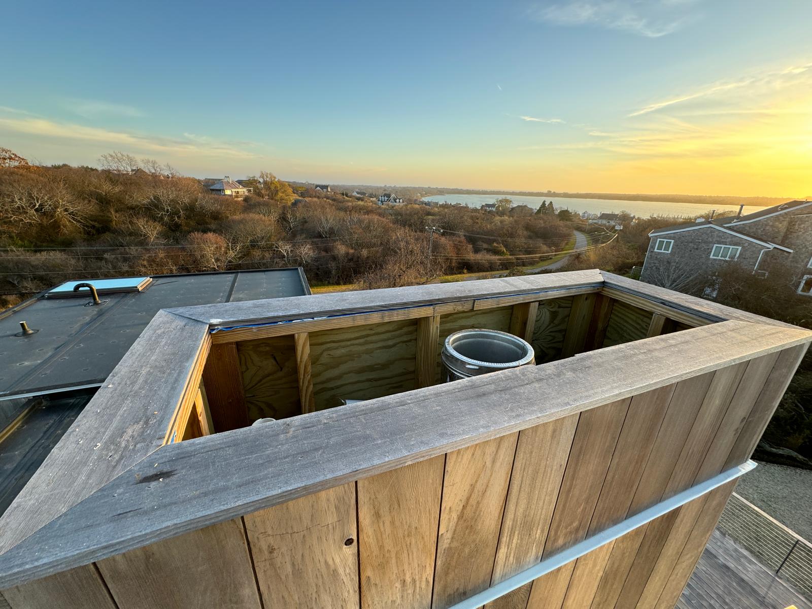 The same wood-clad chimney chase before its new cover, flue exposed