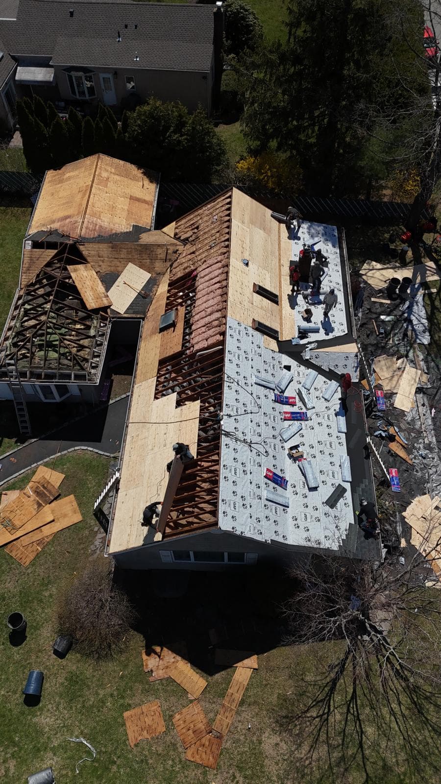 Aerial view of a roof tear-off with new plywood decking and underlayment going down