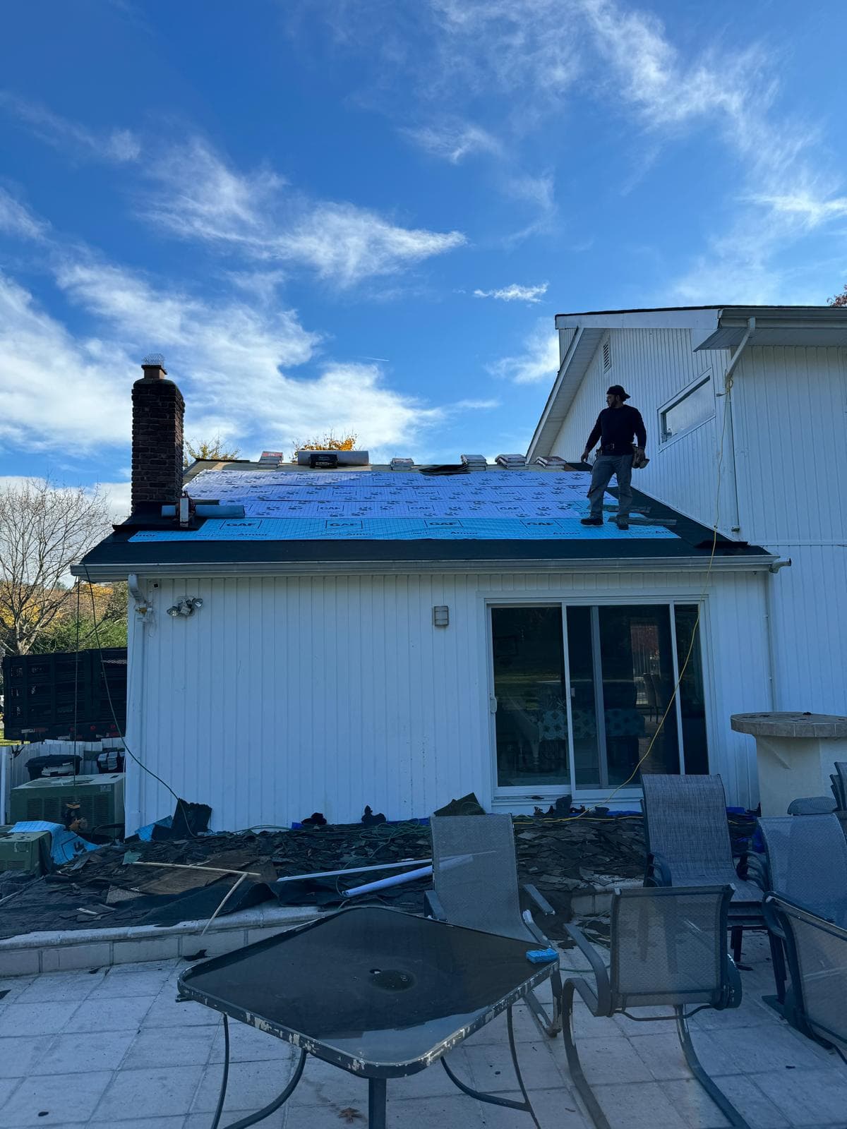 Roofer walking the new underlayment on the same ranch house roof