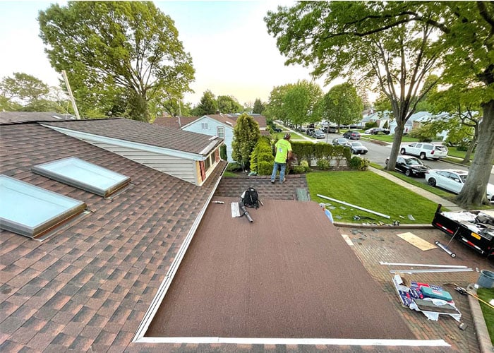 Home Crew roofer on a roof replacement with new skylights on a Long Island ranch house